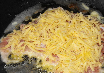 1. Этап. Курица в кляре на сковороде: Сверху присыпаем тертым сыром.