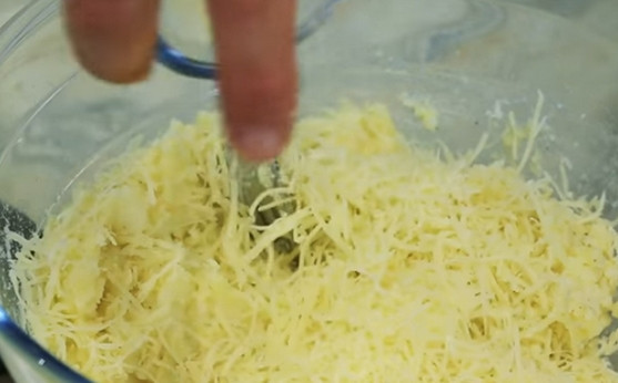1. Этап. Спиральки из картофельного пюре: Засыпаем тертый сыр. Перемешиваем массу.