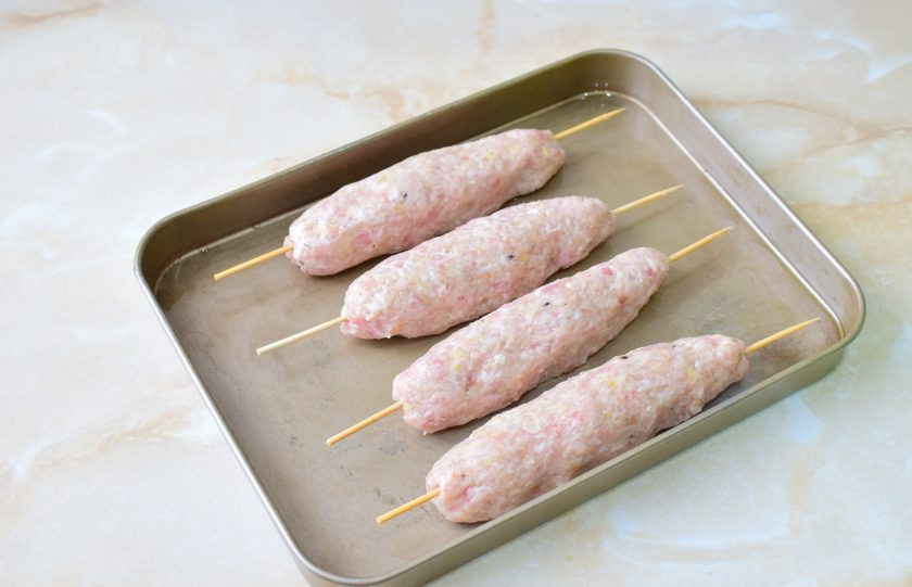 1. Этап. Люля-кебаб из свинины и курицы: Руки смажьте растительным маслом и сформируйте на деревянных шампурах мясные колбаски. Противень для запекания смажьте растительным маслом и выложите на него шпажки с колбасками. Поставьте в духовку, предварительно разогретую до 180 градусов, примерно на 40 минут. Ориентируйтесь по своей духовке.
