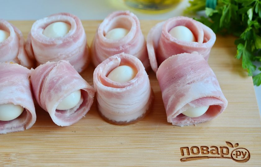 1. Этап. Закуска из яиц в беконе: 3. Каждое яйца заверните в полосочку бекона.