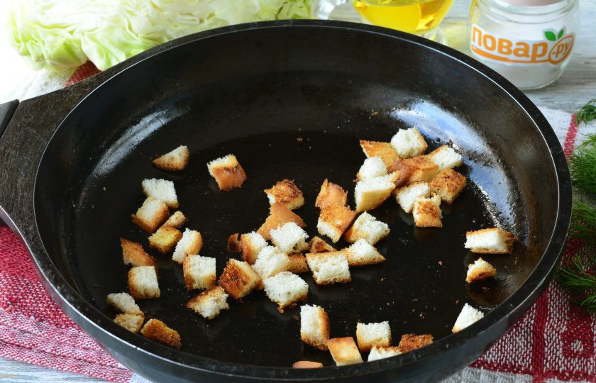 1. Этап. Салат с капустой, ветчиной и сухариками: Обжарьте кубики батона в сухой сковороде до хрустящей корочки и золотистого оттенка. Поджаренные сухарики остудите.