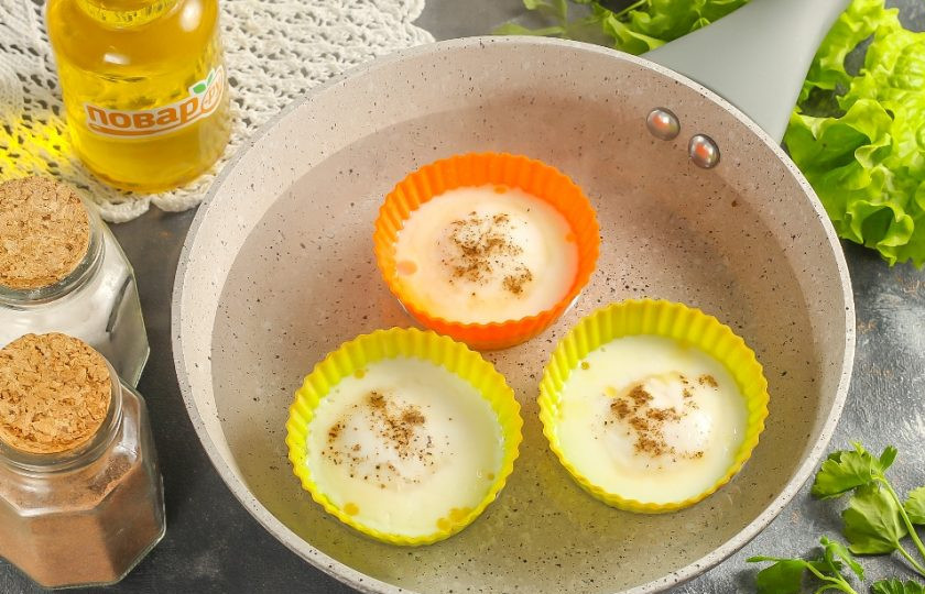 1. Этап. Яйцо пашот в силиконовой форме: Варите ровно три минуты. Белок должен стать плотным, а желток не должен успеть застыть. При движении емкости яйца пашот должны слегка подрагивать. Выключите нагрев и сразу извлеките формочки из горячей воды.