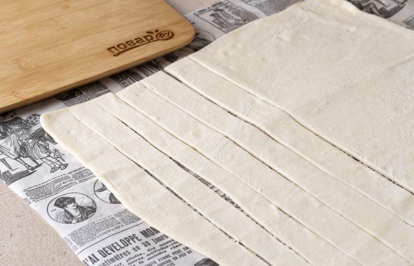 1. Этап. Слоеные трубочки Морковки: Тесто раскатайте толщиной около 3-4 мм. Нарежьте на тонкие полоски около 2,5 см.