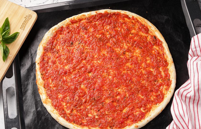 1. Этап. Пицца Нью-йорк: Равномерно распределите соус для пиццы по поверхности основы для пиццы, оставляя бортики пустыми.