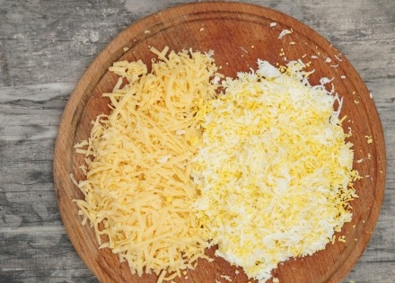 1. Этап. Слоеный салат с крабовыми палочками: 4. Яйца остудите и очистите, натрите на терке. Возьмите хороший твердый сыр и тоже натрите на терке.