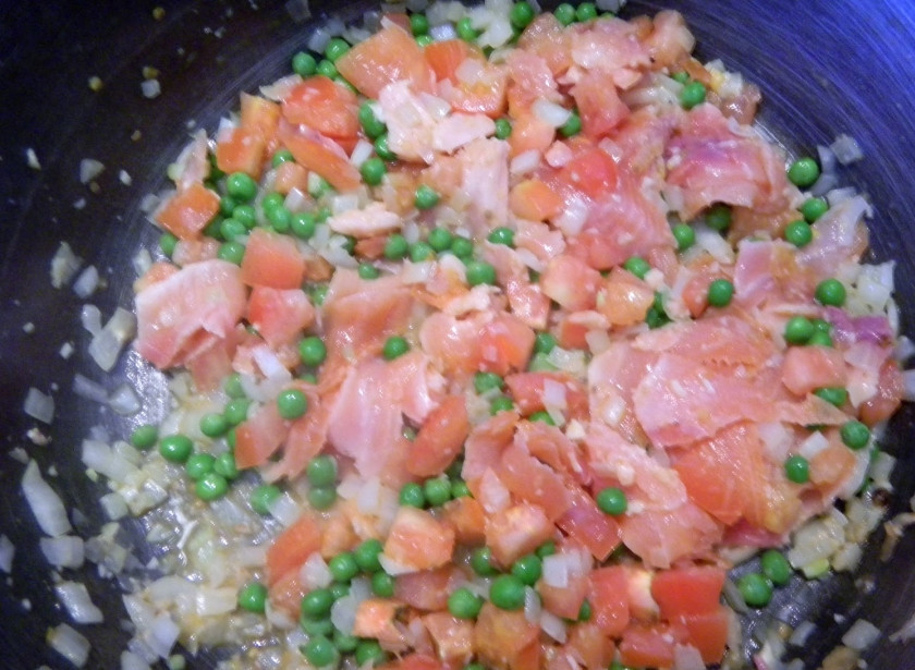 1. Этап. Паста с красной рыбой: 3. Когда лук станет прозрачным, добавьте нарезанные кубиками помидоры и зеленый горошек. Оставьте на среднем огне на 2-3 минуты. После выложите семгу.