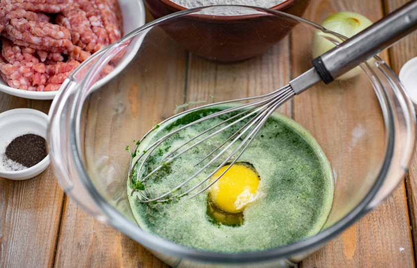 1. Этап. Зелёные пельмени со шпинатом: В просторную миску перелейте содержимое чаши блендера, вбейте яйцо, добавьте соль.