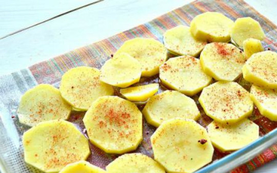 1. Этап. Запеканка картофельная с консервами: 2. Картофель промойте, почистите от кожуры и нарежьте кружочками толщиной около 0,5 см. Возьмите форму для запекания, смажьте растительным маслом. Аккуратно выложите слой картофеля, посолите, поперчите.