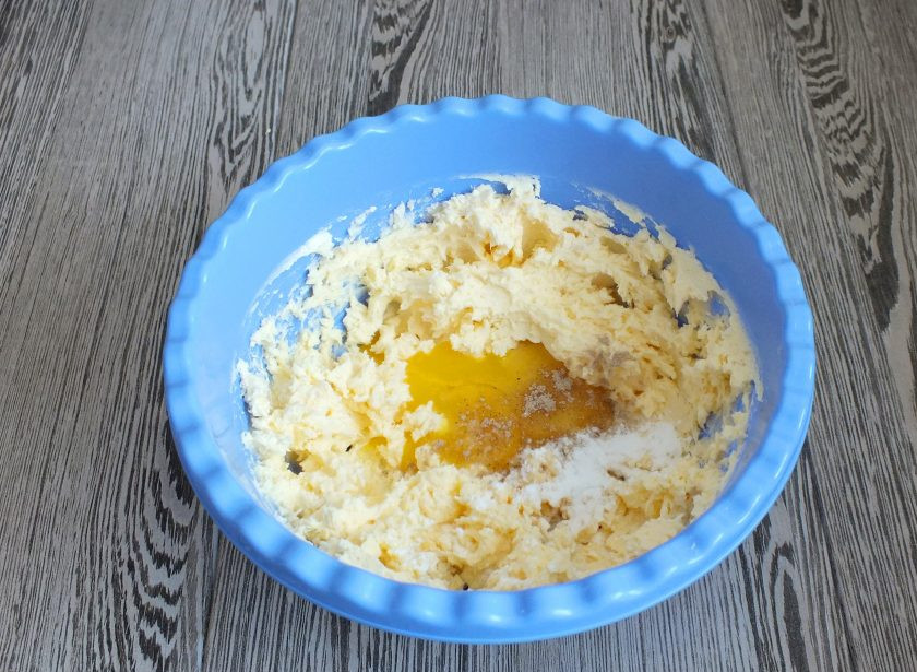 1. Этап. Печенье с лимонной начинкой: В масляную массу добавьте желтки, ванилин, кардамон, разрыхлитель. Снова взбейте.