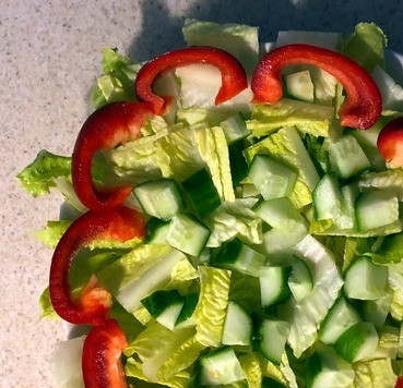 1. Этап. Салат Экзотический цветок: 7. Нарезаем огурец кубиками и выкладываем поверх листьев салата. 8. Нарезаем перец полоскали и выкладываем по краю салата.