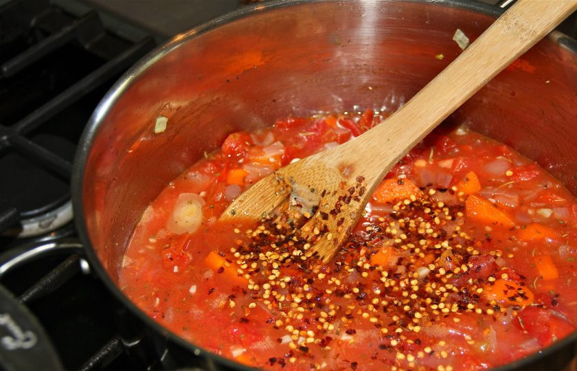 1. Этап. Морской окунь с овощным рагу: 2. Включите огонь на максимум и влейте вино, соскребите со стенок и дна, готовьте около 5-10 минут до испарения жидкости. Очистите кожуру с помидор и нарежьте их кусочками, выложите в кастрюлю, добавьте хлопья красного перца, соль, воду. После закипания тушите все 18-20 минут на среднем огне.