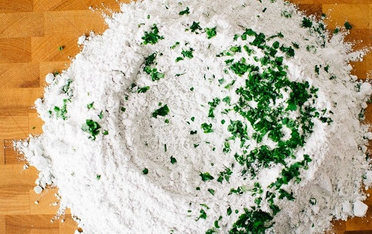 1. Этап. Зеленые макароны: 3. Переложите муку на рабочий стол. Добавьте измельченную зелень.