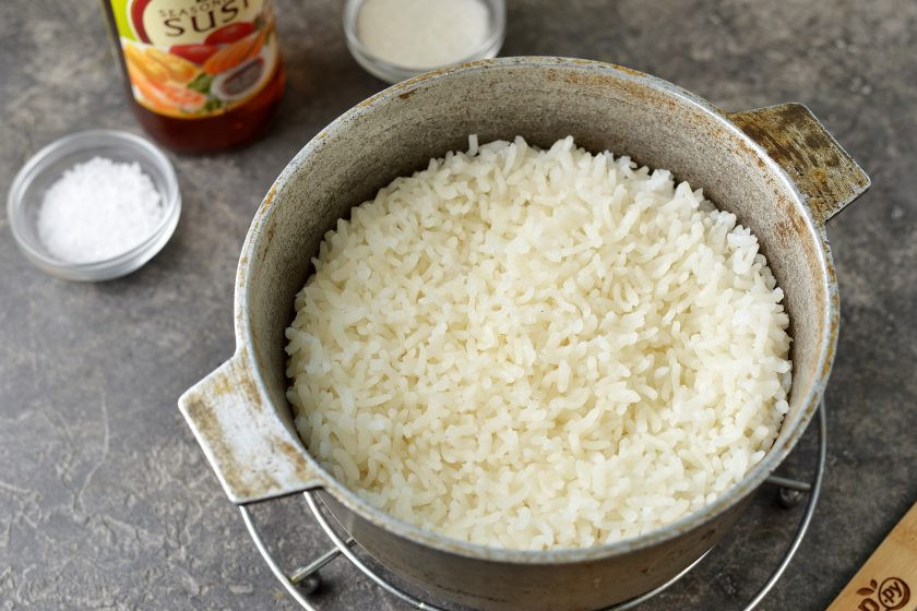 1. Этап. Роллы с икрой мойвы: Рис тщательно промойте несколько раз, переложите в кастрюлю, налейте воды так, чтобы она была выше крупы на 1 сантиметр. После закипания сделайте огонь минимальный, плотно накройте кастрюлю крышкой и варите рис 15 минут. Спустя время снимите казан с плиты, выложите пару бумажных полотенец между крышкой и казаном и оставьте еще на 15 минут. Дальше влейте в рис заправку из уксуса с сахаром и солью, хорошенько перемешайте.