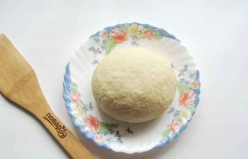 1. Этап. Тесто для вареников на минералке: Переложите тесто на поверхность, присыпанную мукой. Замесите, собирая тесто в шар. Оно должно быть достаточно крутым, плотным, но эластичным.