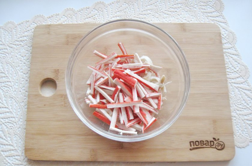 1. Этап. Салат Царская радость: Добавьте крабовые палочки, нарезанные соломкой.