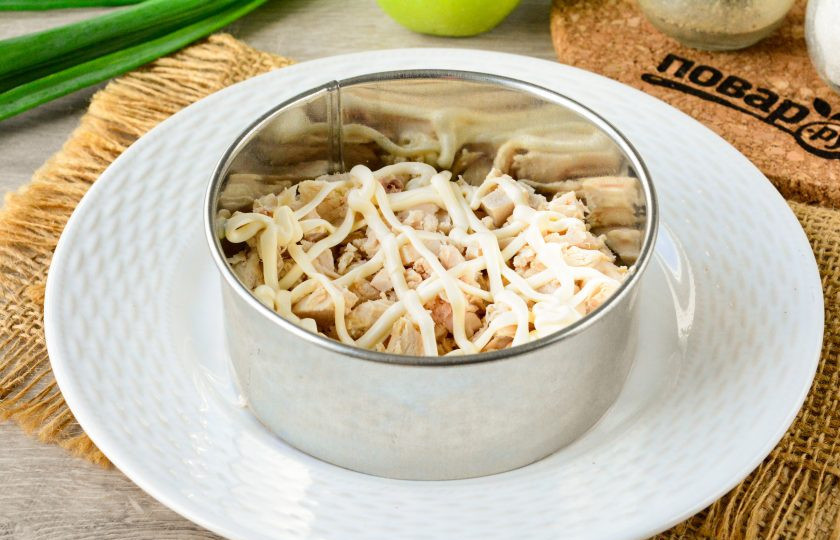 1. Этап. Салат Сказка с черносливом: Отварную куриную грудку нарежьте средними кусочками и выложите первым слоем. Салат выкладывайте при помощи кулинарного кольца.