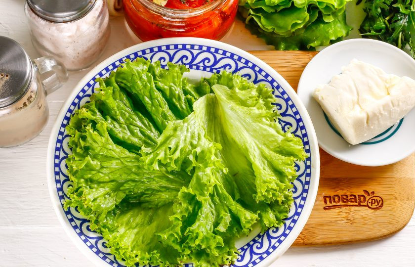 1. Этап. Салат с вялеными помидорами и рукколой: Промойте листья салата в воде, обсушите бумажными салфетками и выложите на тарелку.