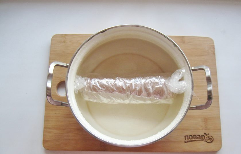 1. Этап. Домашняя колбаса в пакете: В кастрюлю с кипящей водой выложите колбасу в пакете. Прикройте крышкой и варите на самом небольшом огне 45-50 минут.