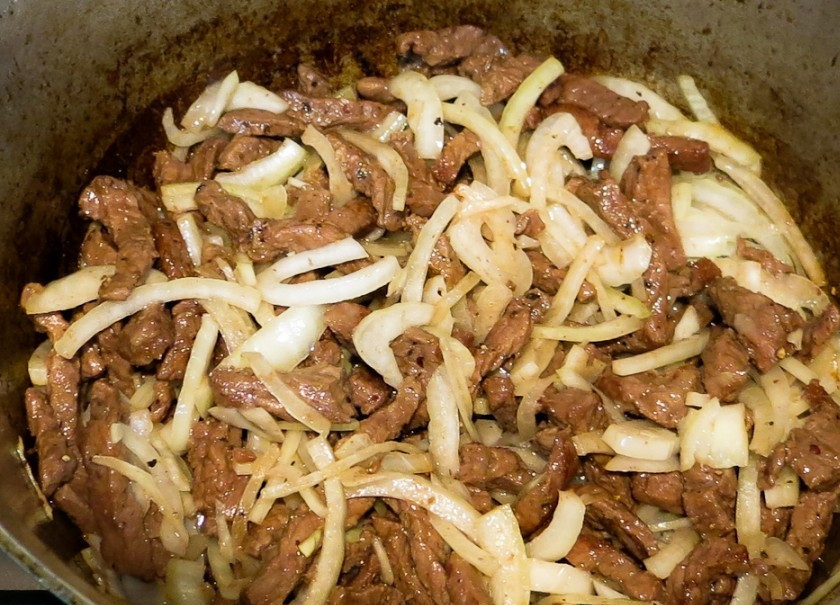 1. Этап. Говядина (тазобедренная часть): Затем добавьте лук. Готовьте блюдо до мягкости. В конце влейте разведённую томатную пасту. Жарьте ингредиенты вместе до выпаривания жидкости.