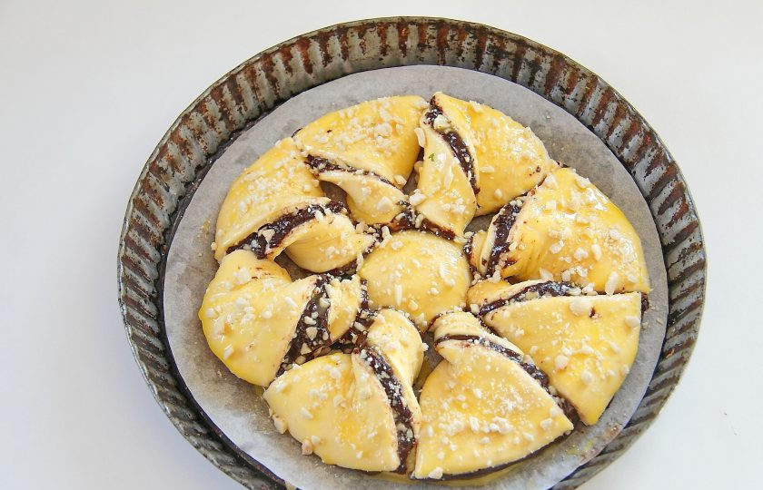 1. Этап. Слоеный шоколадный пирог: 8. Смажьте поверхность желтком и посыпьте оставшимися орехами.