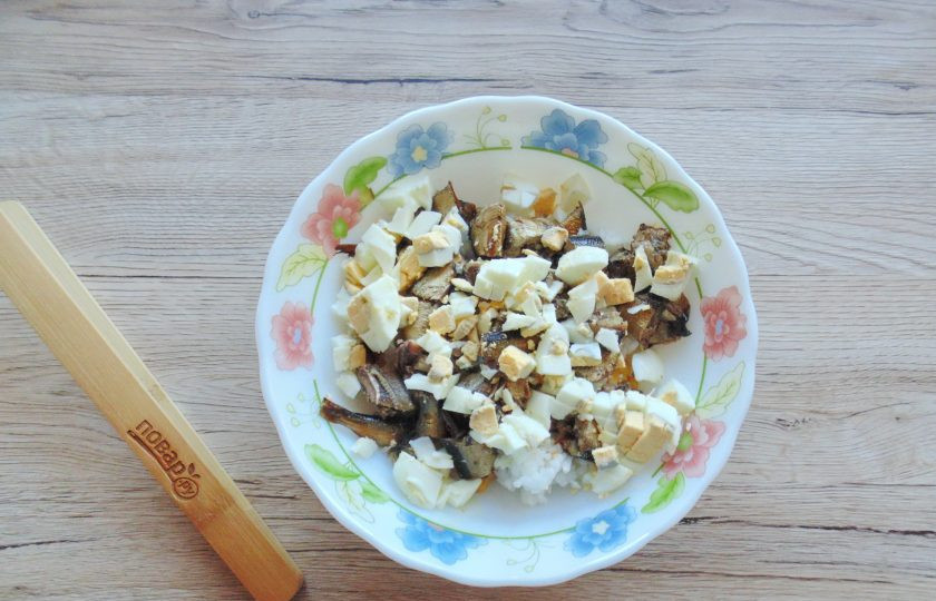 1. Этап. Салат из шпрот и кукурузы: Яйца отварите вкрутую, охладите и очистите. Нарежьте мелко и добавьте в салатник.