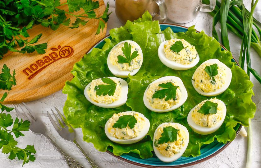 1. Этап. Яйца фаршированные творогом и зеленью: Выложите фаршированные яйца на листья салата и украсьте свежей зеленью перед подачей.