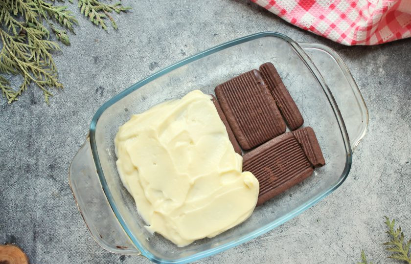 1. Этап. Шоколадно-банановый торт без выпечки за 15 минут: В форму выложите часть шоколадного печенья и покройте частью крема.