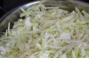 1. Этап. Капустная запеканка с фаршем и грибами: Капусту нарежьте тонкими полосками или маленькими кубиками. 1 кг — это чистый вес, без кочерыжки. Посолите, слегка перетрите руками. В большой сковороде нагрейте 2 ст. л. растительного масла. Выложите в нее капусту и, помешивая, жарьте 5–7 минут. Переложите в миску.