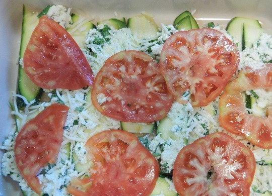 1. Этап. Лазанья с кабачками и помидорами: 5. Вымытые и обсушенные помидоры нарезать тонкими кружочками. Выложить в форму, слегка подсолить. При желании в рецепт приготовления лазаньи с кабачками и помидорами можно также добавить сушеную или свежую зелень.