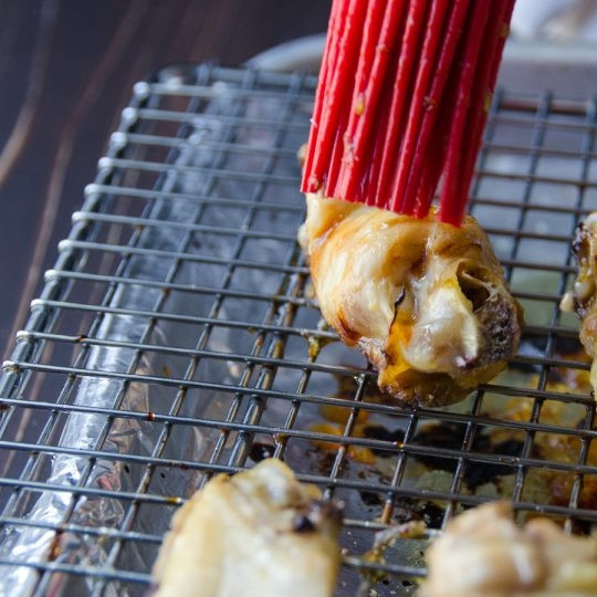 1. Этап. Острые куриные крылышки с медом: Обмажьте крылышки соусом. Поставьте их запекаться на 10 минут.