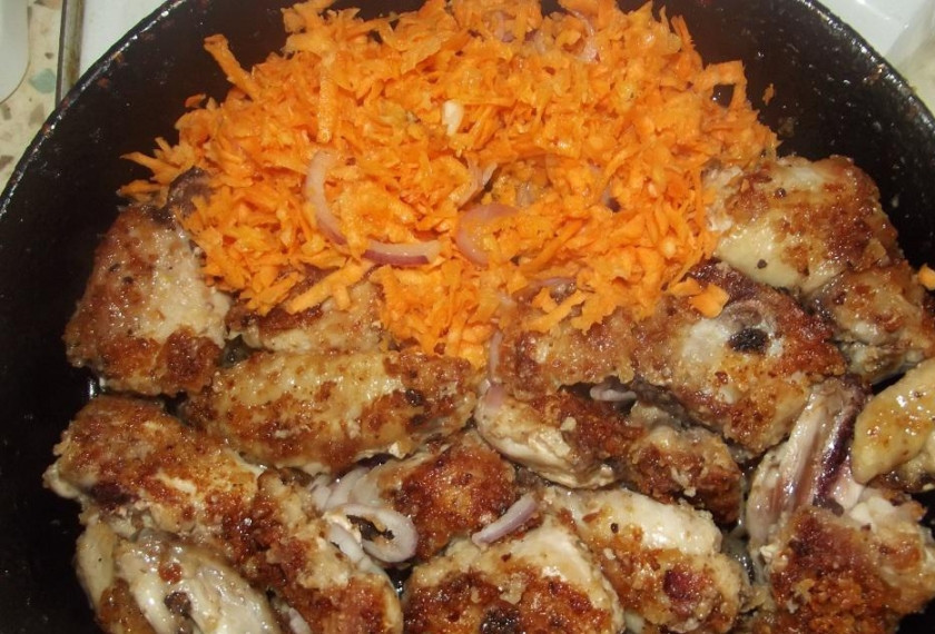 1. Этап. Курица в сухарях: 4. Переворачиваем, и тут же добавляем мелко нарезанные лук с морковкой. Жарим все вместе до готовности лука.