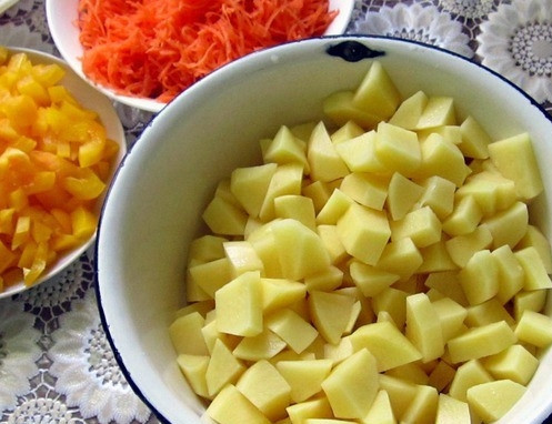 1. Этап. Вкусные горшочки со свининой: Картошечку промойте, очистите и нарубите на кубики острым ножом. Все овощи должны быть приблизительно равного размера.