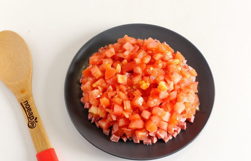 1. Этап. Салат с копчёной колбасой: Следом выложите нарезанные примерно такими же кубиками помидоры. Если помидоры сильно сочные, то предварительно откиньте их на сито.