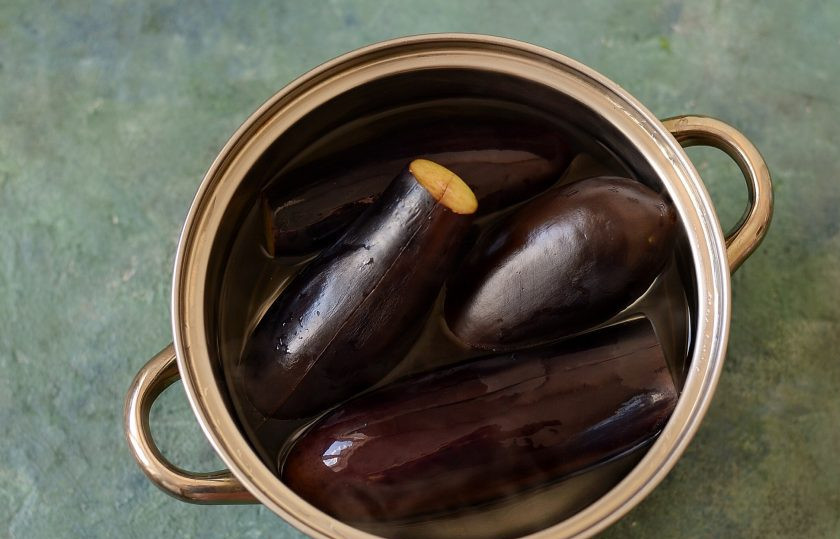 1. Этап. Турша из баклажанов: Баклажаны помойте, отрежьте хвостики. Надрежьте вдоль, но не разрезайте до конца. Отварите в кипящей воде примерно 10-15 минут до мягкости. Время зависит от размеров баклажанов.