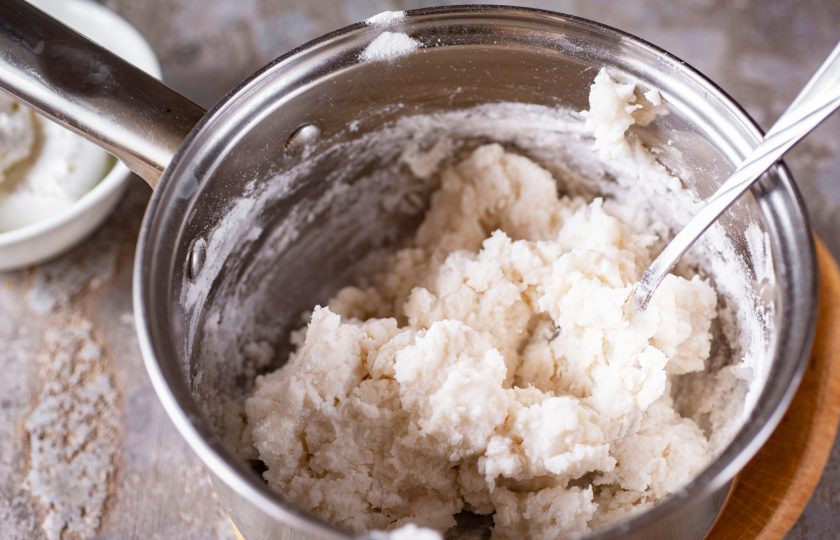 1. Этап. Вареники из рисовой муки: Сотейник снимите с плиты и добавьте в кипяток 150 грамм рисовой муки. Активно перемешайте все ложкой.