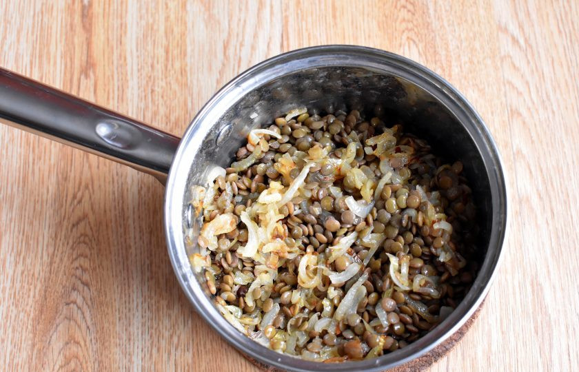 1. Этап. Чечевица с луком: Попробуйте чечевицу на вкус через полчаса тихого кипения. Если она почти готова, слейте излишек воды. Заправьте чечевицу жареным луком, перемешайте. Попробуйте и при необходимости досолите. Прогрейте чечевицу с луком 5 минут на минимальном нагреве, дав возможность пропитаться ароматами.