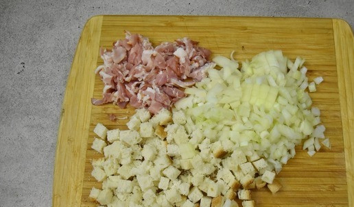 1. Этап. Рулет из индейки с беконом: Для начинки нарежьте кубиком лук, бекон и хлеб.