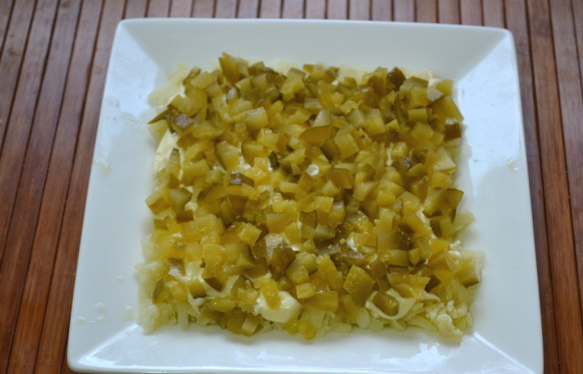 1. Этап. Салат новогодний Адвент: Нарежьте мелко огурцы, выложите их следующим слоем.