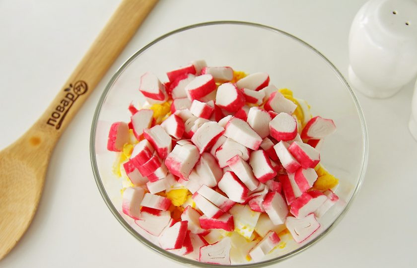 1. Этап. Салат Коралл: Добавьте нарезанные примерно таким же размером крабовые палочки.