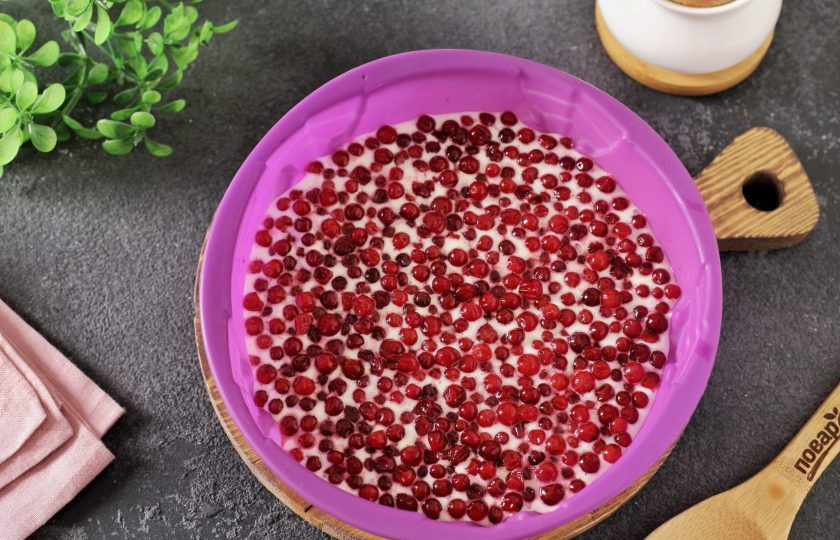 1. Этап. Шарлотка с брусникой: В смазанную маслом форму выложите примерно половину порции теста и сверху хаотично распределите бруснику.