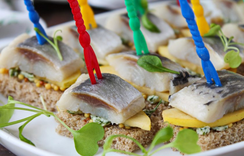 1. Этап. Канапе с селедкой и черным хлебом на шпажках: Каждую канапе закрепите шпажкой посередине, протыкая все слои. Переложите канапе на сервировочное блюдо, украсьте зеленью и подавайте к столу.