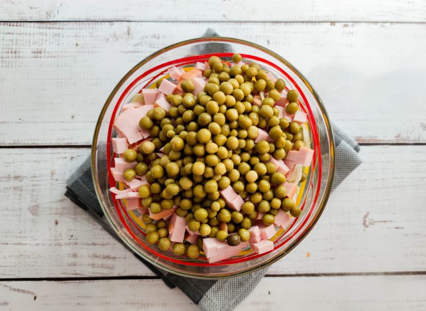 1. Этап. Салат из капусты, горошка и колбасы: Высыпьте консервированный горошек.