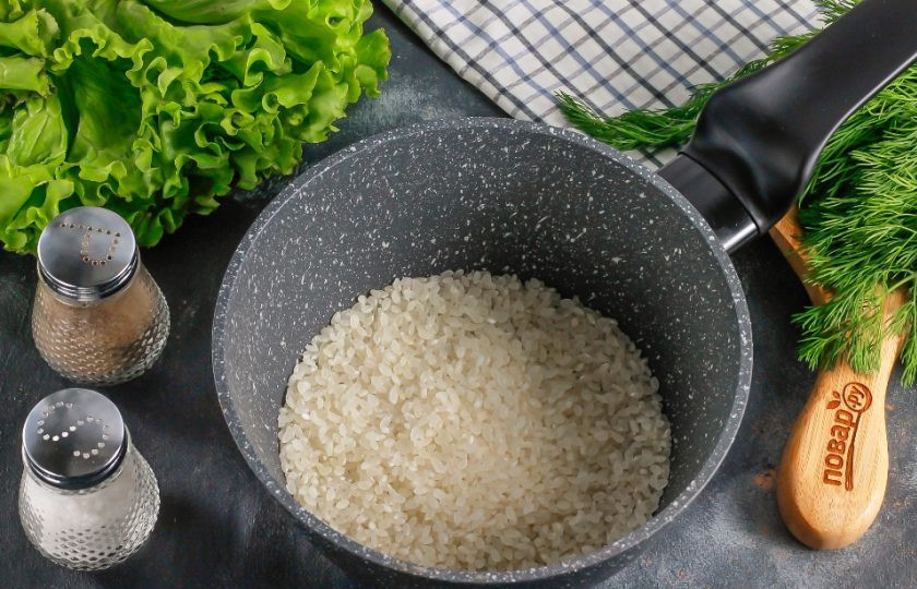 1. Этап. Онигири с лососем: Рис тщательно промойте в воде 4-5 раз и высыпьте в казан или в ковш с антипригарным дном. Влейте горячую воду и отварите примерно 15 минут. Затем перемешайте и оставьте под крышкой набухать, выключив нагрев. Имейте в виду, что рис для онигири отваривается без специй и вкусовых добавок!