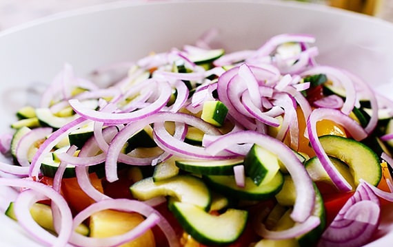 1. Этап. Итальянский салат Панцанелла: 4. Нарежьте лук на тонкие полукольца и смешайте с овощами и сухариками.