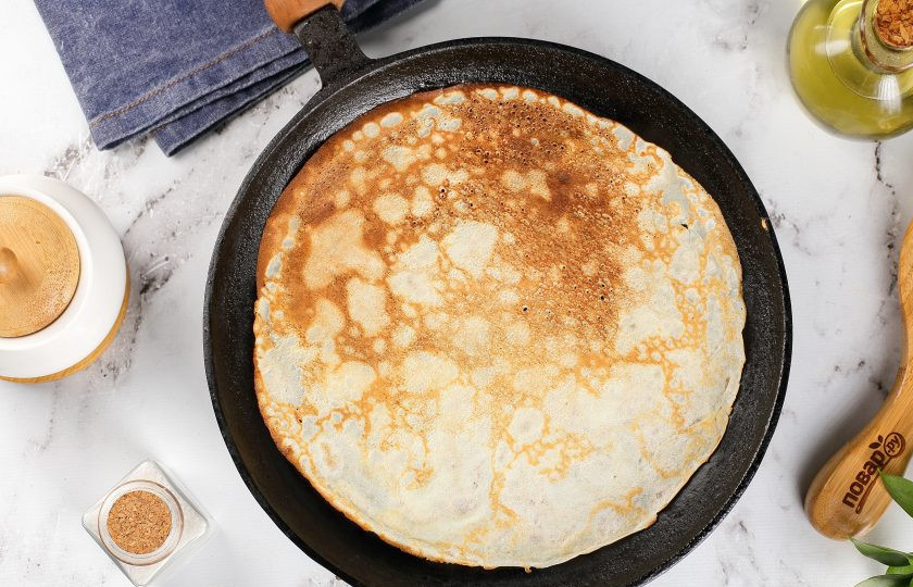 1. Этап. Русские блинчики: Разогрейте сковороду и первый раз смажьте её маслом. Налейте половником небольшое количество теста, равномерно распределяя его по кругу и обжарьте блинчик с двух сторон.