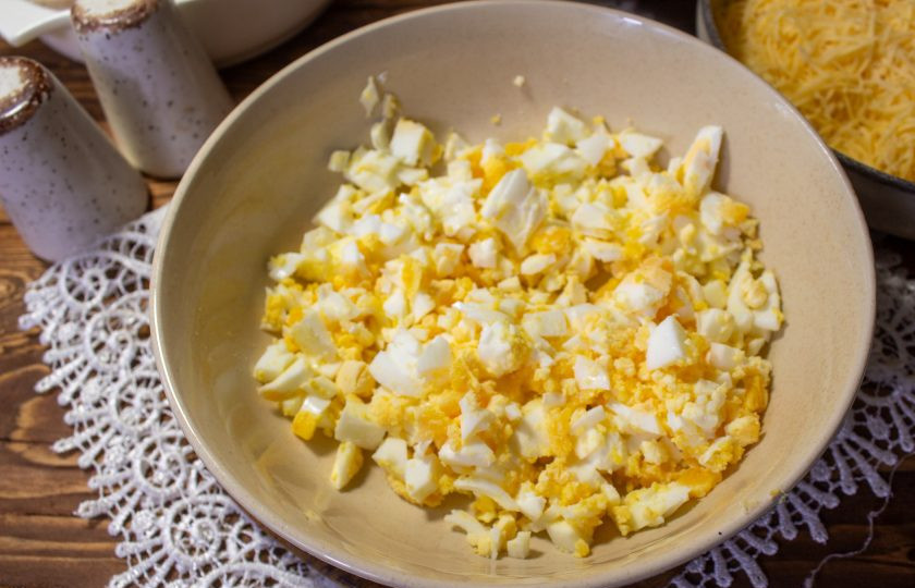 1. Этап. Салат Кусочек сыра: Куриные яйца очистите и нарежьте мелкими кубиками.