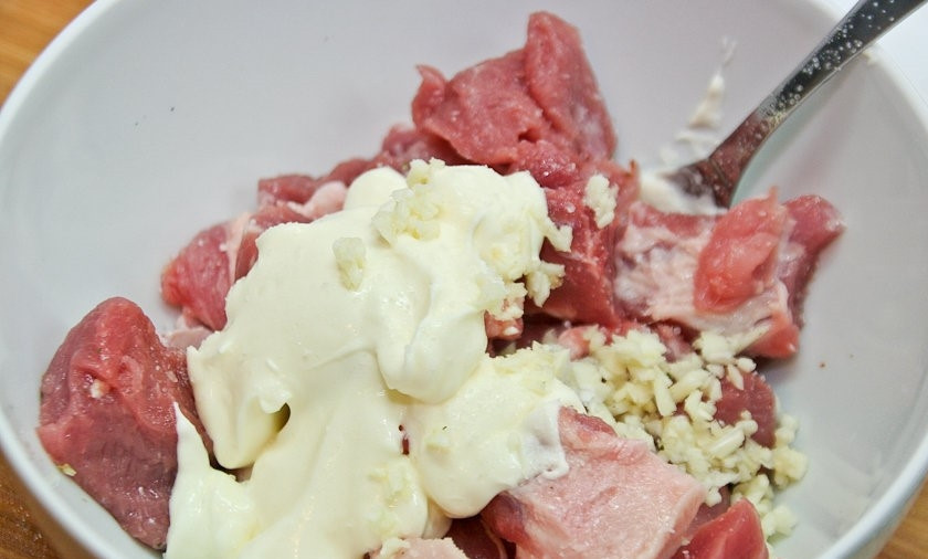 1. Этап. Слоеная картошка со свининой: 5. Соедините майонез с остальной частью чеснока и мясом.