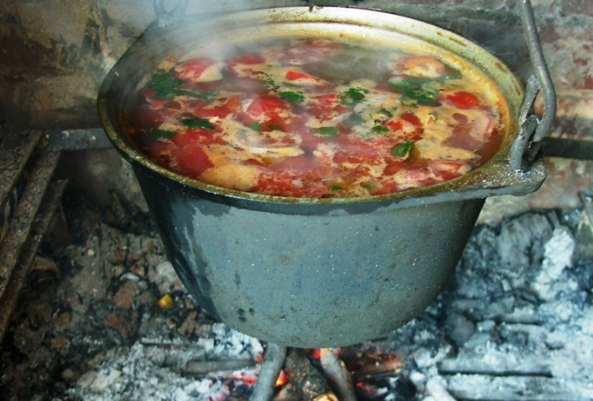 1. Этап. Шулюм из баранины на костре: Отправляем картофель в котелок, добавляем лавровый лист, душистый перец, соль и специи по вкусу, варим суп до готовности картофеля. За пару минут до конца варки, выкладываем в котелок измельченную зелень и чеснок.