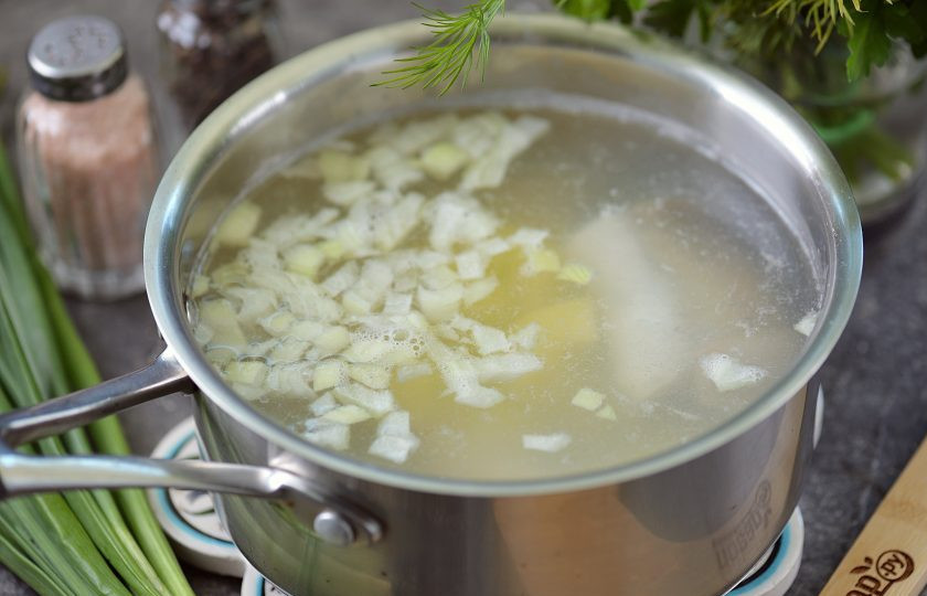 1. Этап. Уха из замороженной рыбы: Как только вода закипит, соберите всю пену, добавьте мелко нарезанный репчатый лук и кубиком картофель, варите минут 10.