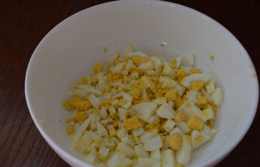 1. Этап. Салат с колбасой и сыром: Отварите яйца. Очистите их. Нарежьте мелким кубиком.